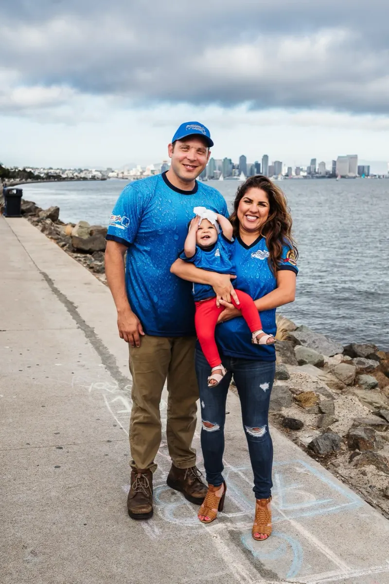 Joe and Shovan Dufresne — owners of Commercial Cleaning of San Diego — on the San Diego waterfront with the downtown skyline behind them